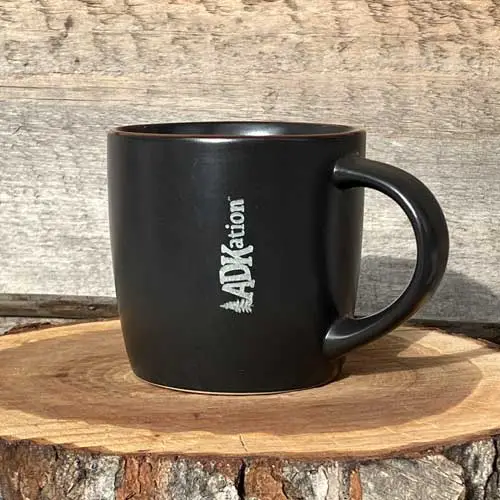 ADKation Life | A dark, modern beverage mug featuring the fun ‘ADK’ and ‘vacation’ word mash up, ‘ADKation’ engraved vertically near the handle. | An emotionally soothing Adirondack vacation gift or souvenir to enjoy at home, the office, or in front of a cozy fire.