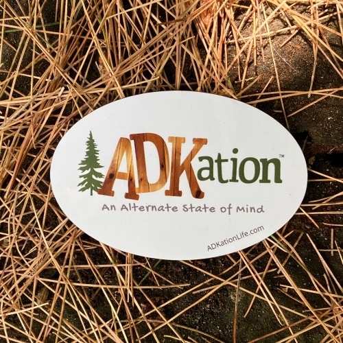 Oval ADK vacation souvenir magnets with the text ‘ADKation’ as a joyful reminder to unforgettable vacations in Adirondacks of upper New York state.