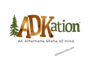 Capturing the interior pine walls popular in camps within the Adirondack Mountains, this Knotty Pine ADKation Magnet will be one of your favorites. Evergreen tree in front of pine paneling filled text “ADK” as part of full “ADKation” text. The tag line “An Alternate State of Mind” follows, with adkationlife.com at the bottom.